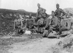 Солдаты позируют на фоне 3,7-см пехотного орудия образца 1915 г. Минимум один, который смотрит в перископический прицел, является членом расчета — у него на поясе висит кожаный футляр от этого оптического прибора. (Итальянский фронт)