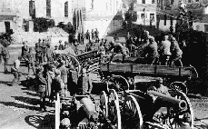 Итальянские солдаты грузят трофейные 15-см тяжелые полевые гаубицы М94 и 8-см полевые пушки М5/8