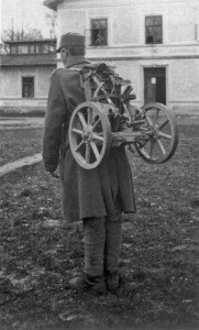 Член расчета 3,7-см пехотного орудия образца 1915 г. переносит станину со смонтированными на ней колесами.